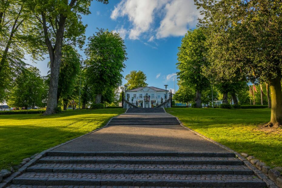 Lush green park in Horsens, Denmark with a scenic pathway leading to a historic building.