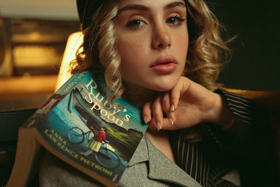 Young woman with book resting on shoulder
