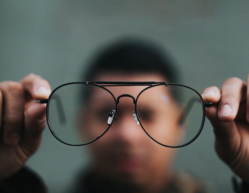 man holding eyeglasses